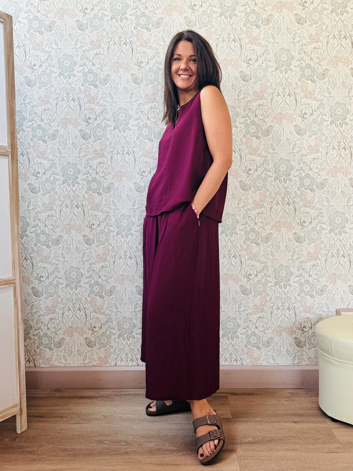 Completo con blusa da taglio svasato con scollo a V e pantaloni alla caviglia con elastico in vita e tasche laterali. 