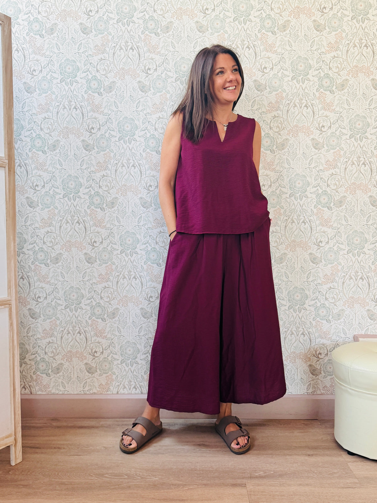 Completo con blusa da taglio svasato con scollo a V e pantaloni alla caviglia con elastico in vita e tasche laterali.