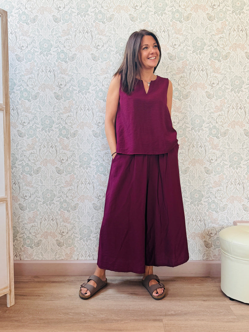 Completo con blusa da taglio svasato con scollo a V e pantaloni alla caviglia con elastico in vita e tasche laterali.
