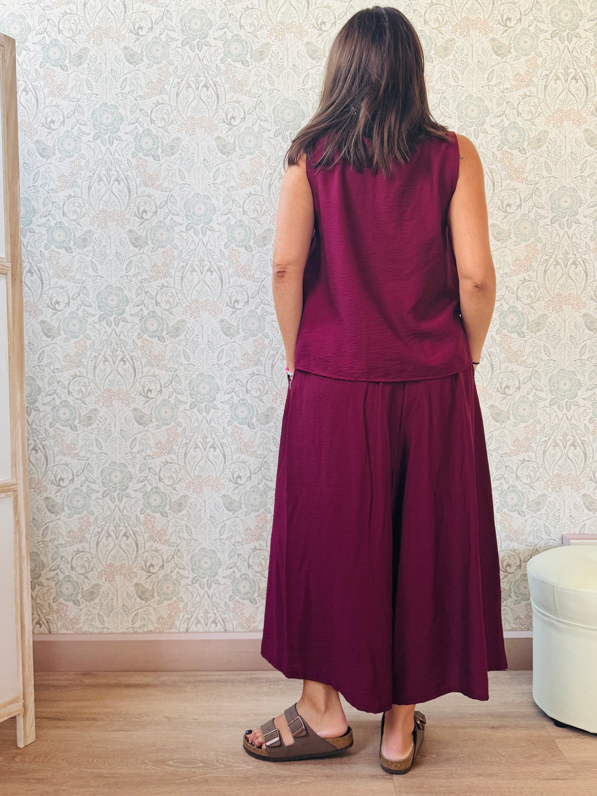 Completo con blusa da taglio svasato con scollo a V e pantaloni alla caviglia con elastico in vita e tasche laterali.