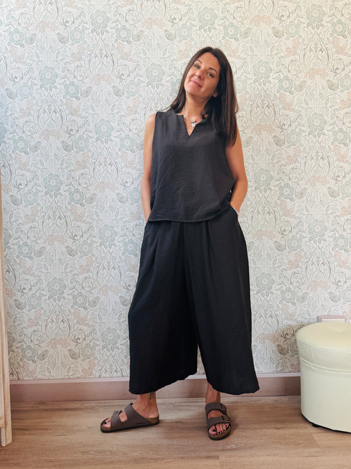 Completo con blusa da taglio svasato con scollo a V e pantaloni alla caviglia con elastico in vita e tasche laterali.