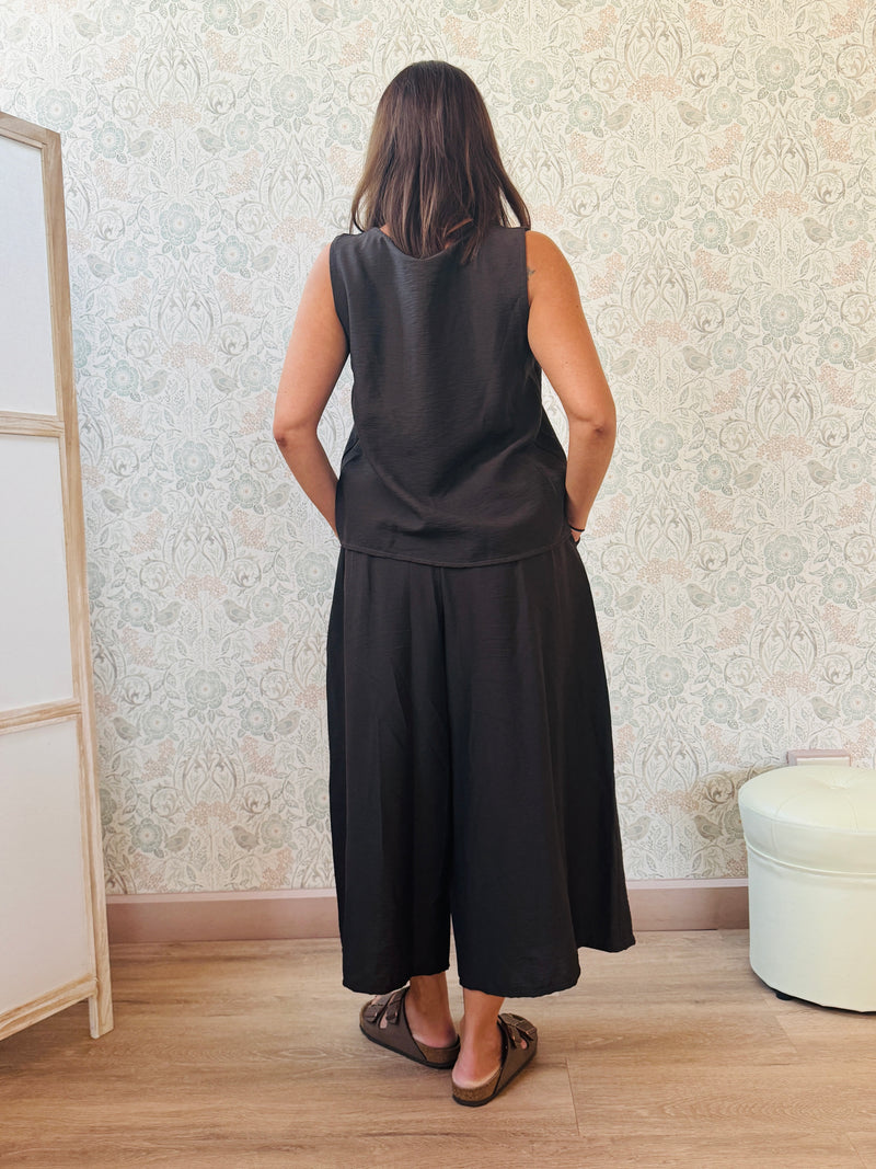 Completo con blusa da taglio svasato con scollo a V e pantaloni alla caviglia con elastico in vita e tasche laterali.