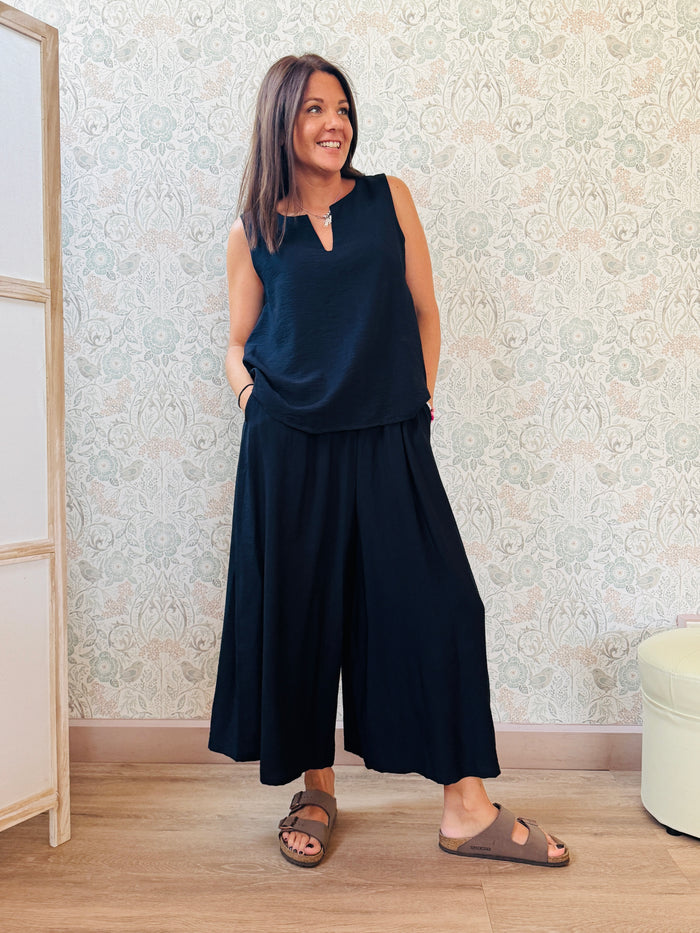 Completo con blusa da taglio svasato con scollo a V e pantaloni alla caviglia con elastico in vita e tasche laterali.