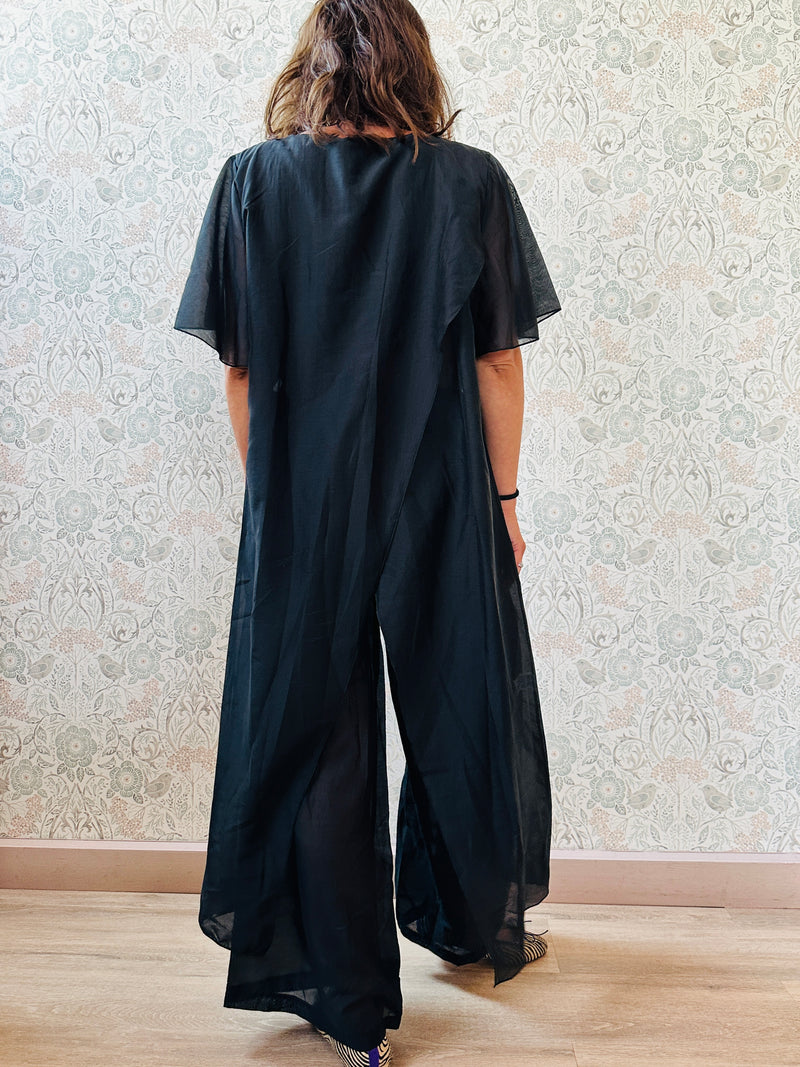 Completo composto da: pantaloni a palazzo con elastico in vita e pantaloncini interno + blusa lunga a manica corta, scollo tondo e taglio a portafoglio