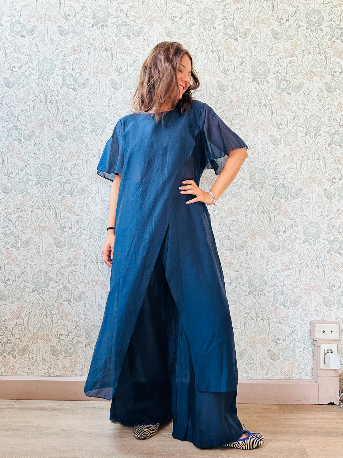 Completo composto da: pantaloni a palazzo con elastico in vita e pantaloncini interno + blusa lunga a manica corta, scollo tondo e taglio a portafoglio