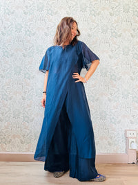 Completo composto da: pantaloni a palazzo con elastico in vita e pantaloncini interno + blusa lunga a manica corta, scollo tondo e taglio a portafoglio