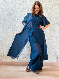 Completo composto da: pantaloni a palazzo con elastico in vita e pantaloncini interno + blusa lunga a manica corta, scollo tondo e taglio a portafoglio