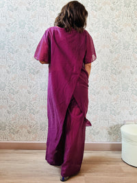 Completo composto da: pantaloni a palazzo con elastico in vita e pantaloncini interno + blusa lunga a manica corta, scollo tondo e taglio a portafoglio