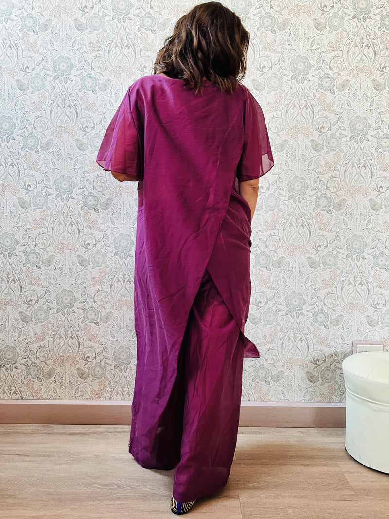Completo composto da: pantaloni a palazzo con elastico in vita e pantaloncini interno + blusa lunga a manica corta, scollo tondo e taglio a portafoglio
