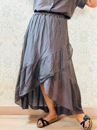 Completo marrone composto da: gonna con balza finale, taglio portafoglio asimmetrico e camicia a manica corta.