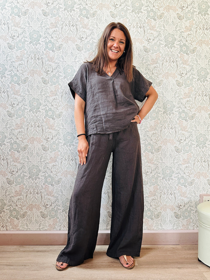 Completo Maldive Marrone: Completo 100% lino composto da pantalone a palazzo  e blusa a manica corta, scollo a V e taglio svasato. 