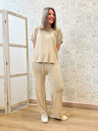 Completo beige fresco con elastico in vita e lacci nei pantaloni e maglietta a manica corta.  