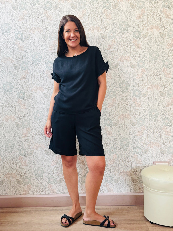 Completo donna composto da blusa a manica corta dal taglio leggermente svasato e bermuda con elastico in vita. 