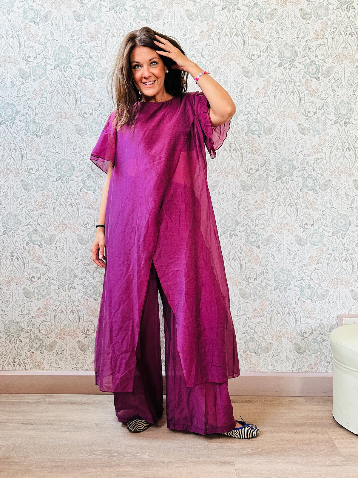 Completo composto da: pantaloni a palazzo con elastico in vita e pantaloncini interno + blusa lunga a manica corta, scollo tondo e taglio a portafoglio