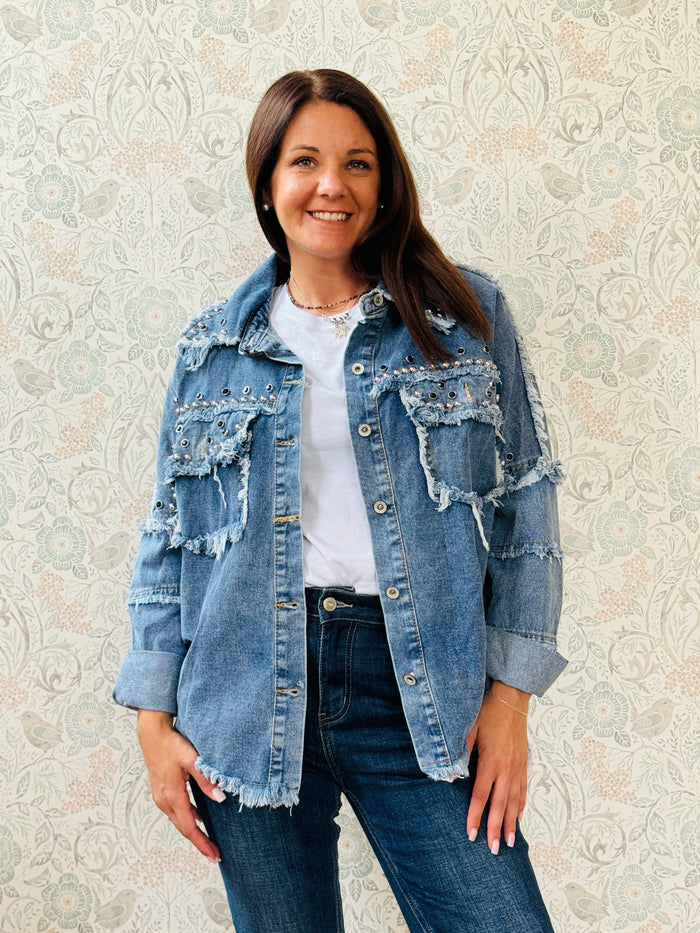 Giacca jeans in tessuto denim dal taglio dritto e molto ampio, tasche a vista aperte sul davanti con applicazioni e dettagli sfrangiati. 