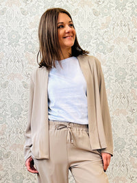 Giacca blazer dotata di spalline imbottite. Rimane aperta. 