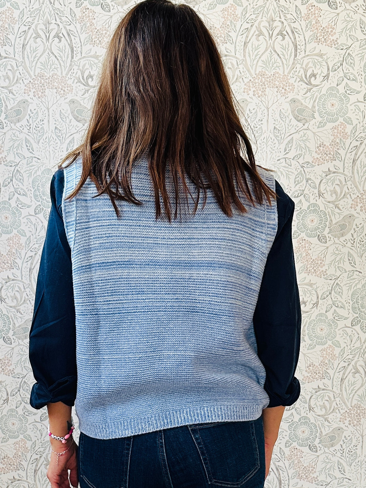 Gilet in maglia senza maniche con scollo a V, lavorazione a costine e sfumature melange.