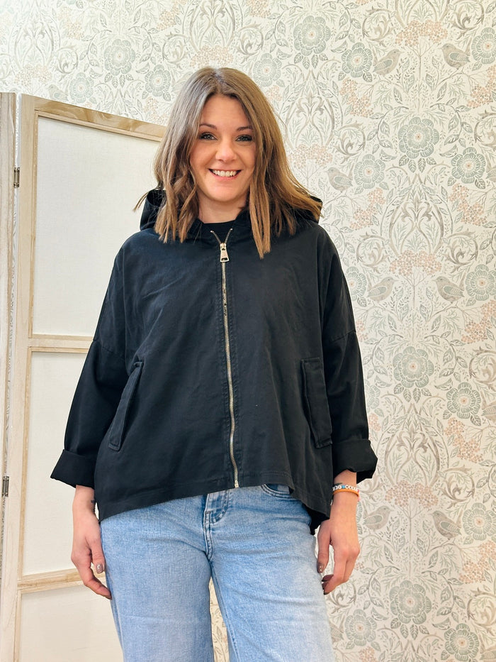 Parka nero leggero dotato di zip, tasconi e cappuccio.  