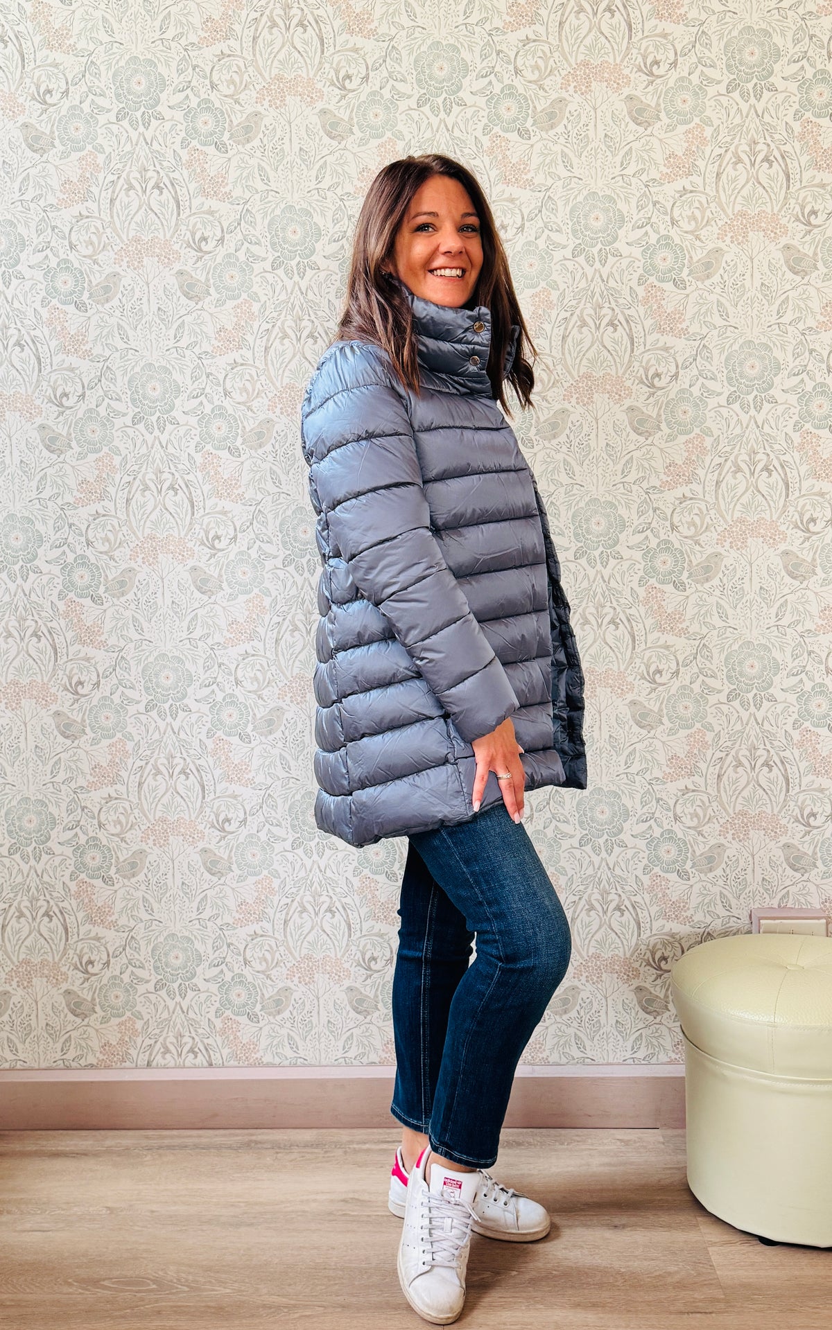 Giubbotto Piumino color blue jeans, lungo con collo alto e chiusura con bottoni a pressione. Tasche laterali con zip.    