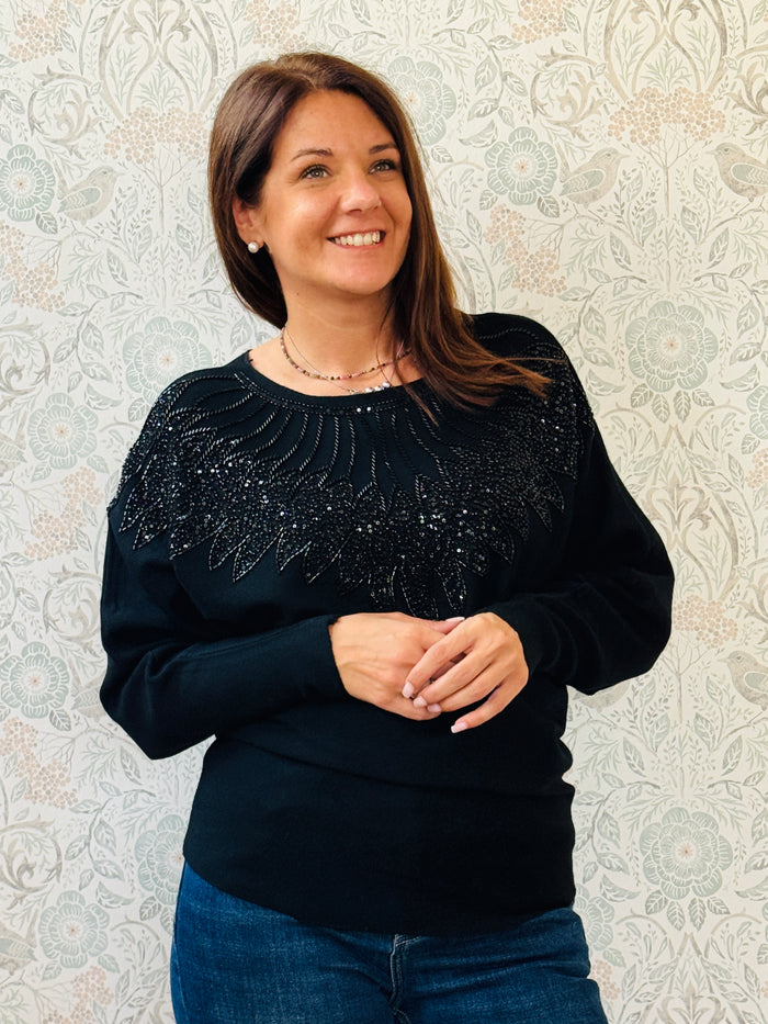 Maglione donna con scollo leggermente a barchetta e manica a pipistrello. Applicazioni sul davanti con paillettes. Taglia unica consigliata fino alla 44/46. 