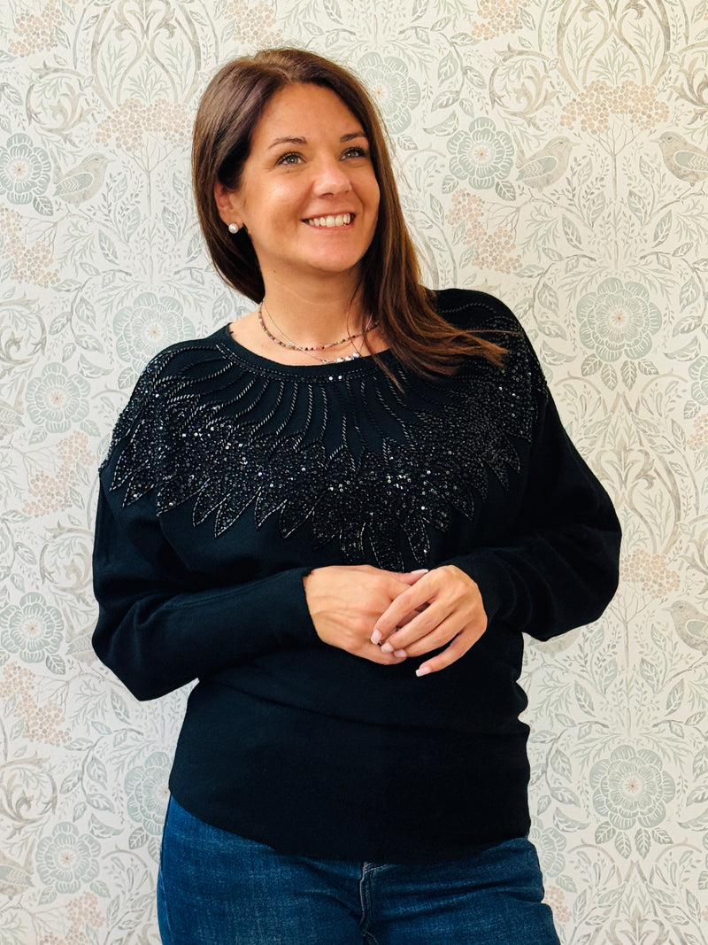 Maglione donna con scollo leggermente a barchetta e manica a pipistrello. Applicazioni sul davanti con paillettes. Taglia unica consigliata fino alla 44/46. 