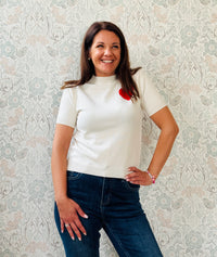 Maglione a manica corta con scollo tondo e cuore stampato. Vestibilità regolare, perfetto anche come sottogiacca. 