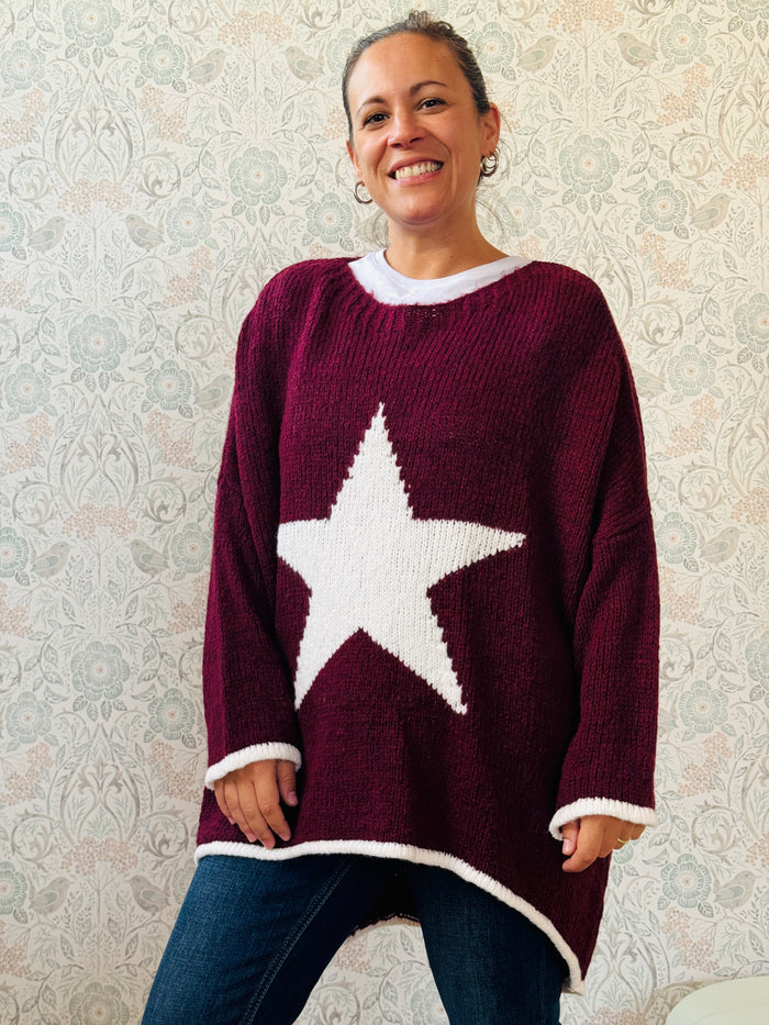 Maglione con scollo tondo, ampio e svasato. Dettaglio stella sul davanti e riga a contrasto sui bordi delle maniche e sul bordo finale. 