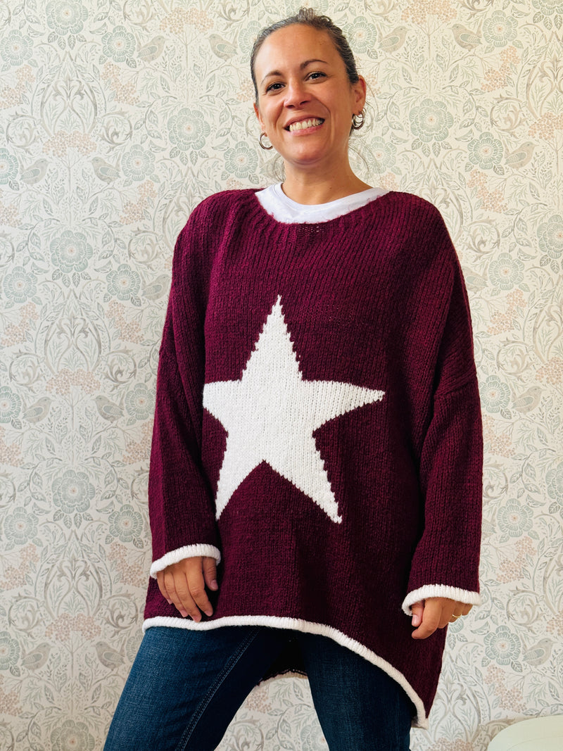 Maglione con scollo tondo, ampio e svasato. Dettaglio stella sul davanti e riga a contrasto sui bordi delle maniche e sul bordo finale. 