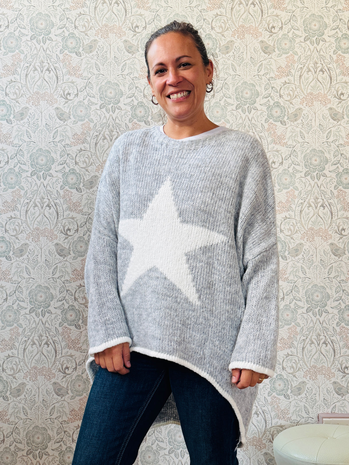 Maglione con scollo tondo, ampio e svasato. Dettaglio stella sul davanti e riga a contrasto sui bordi delle maniche e sul bordo finale.  