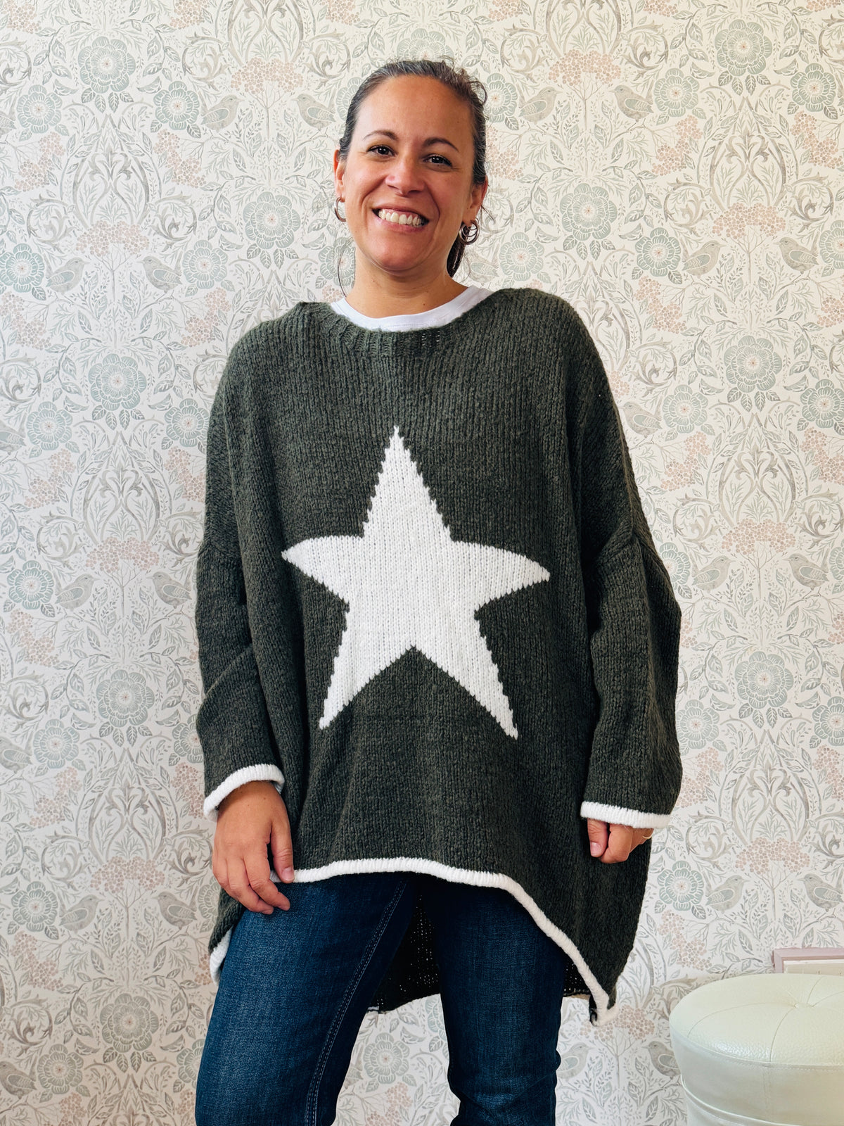 Maglione con scollo tondo, ampio e svasato. Dettaglio stella sul davanti e riga a contrasto sui bordi delle maniche e sul bordo finale.   