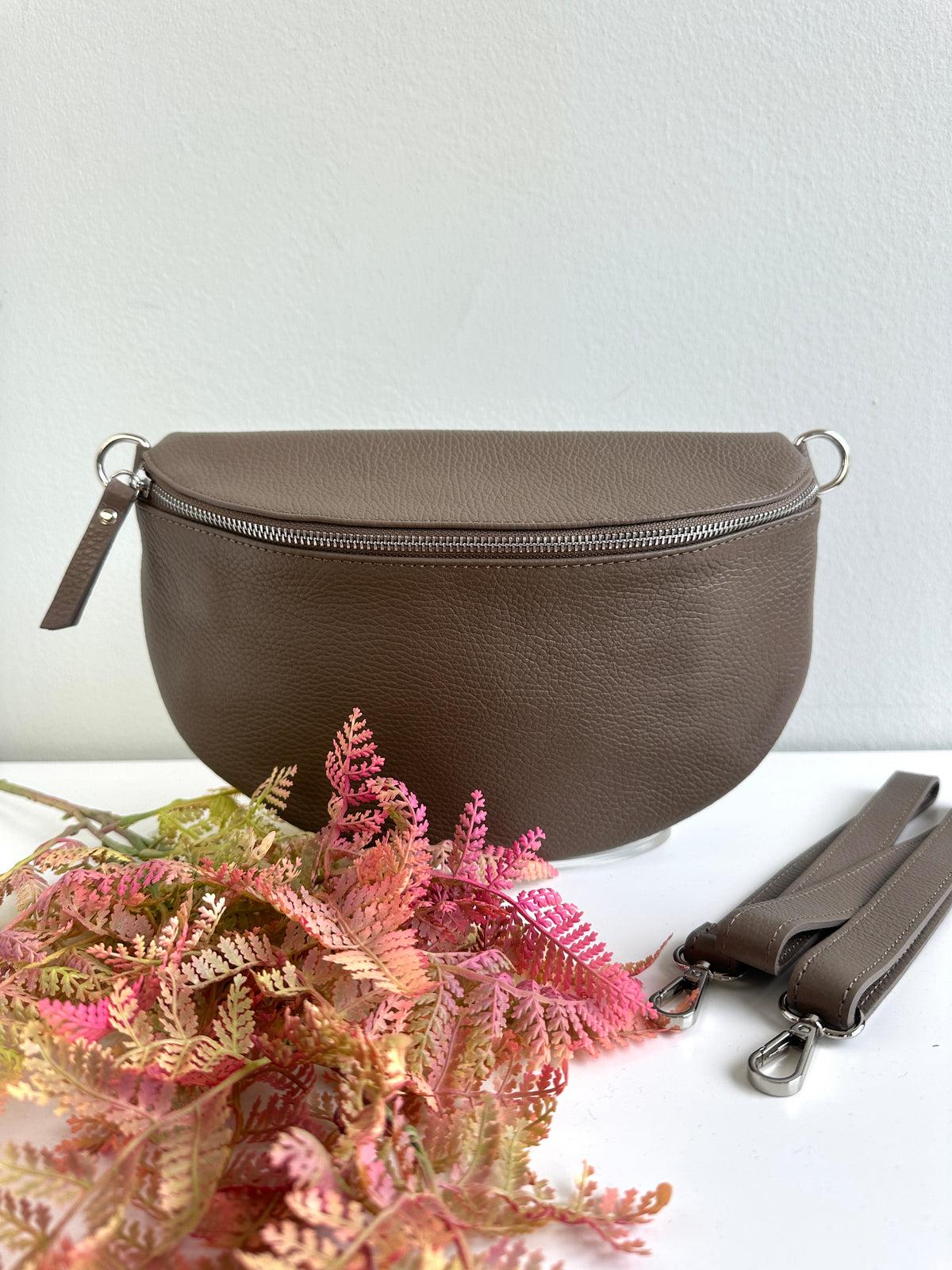 Marsupio tracolla realizzato in vera pelle, con fibbia regolabile e zip. 