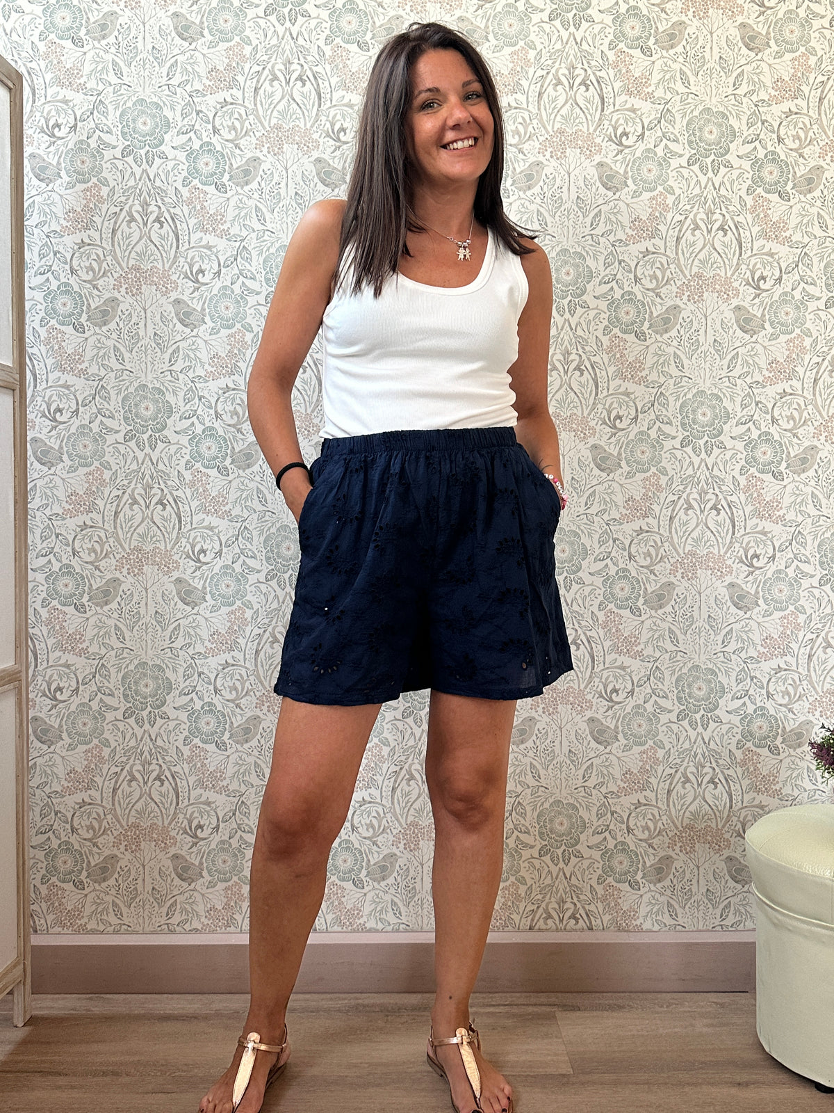 Pantaloncini 100% cotone con elastico in vita, tasche laterali e ricami sangallo. 