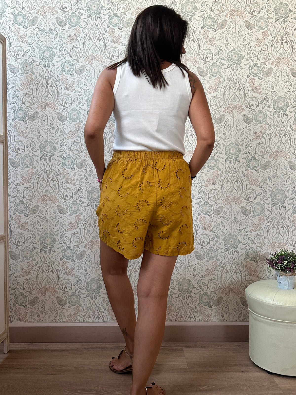 Pantaloncini 100% cotone con elastico in vita, tasche laterali e ricami sangallo. 