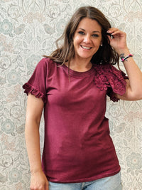 T-shirt bordeaux a manica corta con dettaglio volant e sangallo. Scollo tondo, taglio dritto e leggermente svasato.
