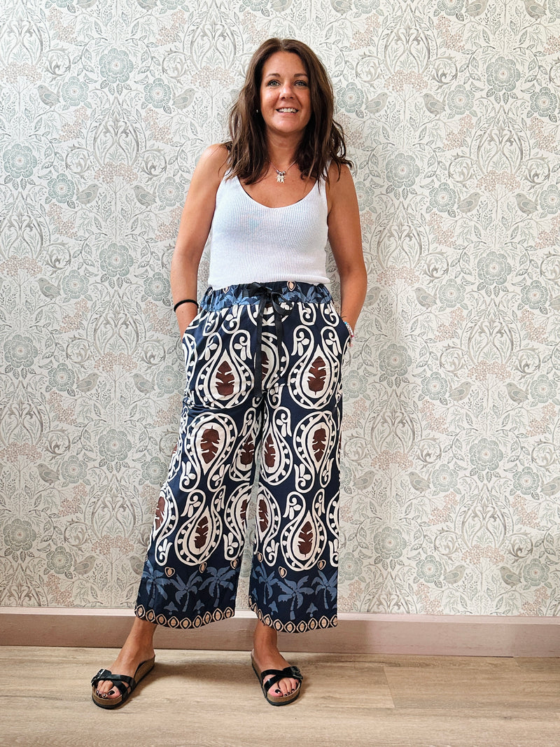Top con scollo a V fronte e retro. Trama a costine e taglio dritto ed aderente.