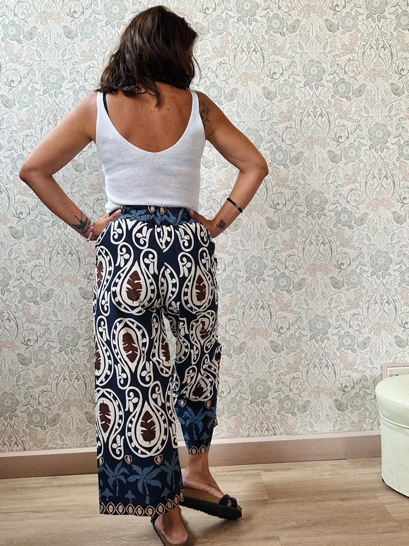 Top con scollo a V fronte e retro. Trama a costine e taglio dritto ed aderente.
