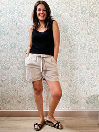 Top con scollo a V fronte e retro. Trama a costine e taglio dritto ed aderente.