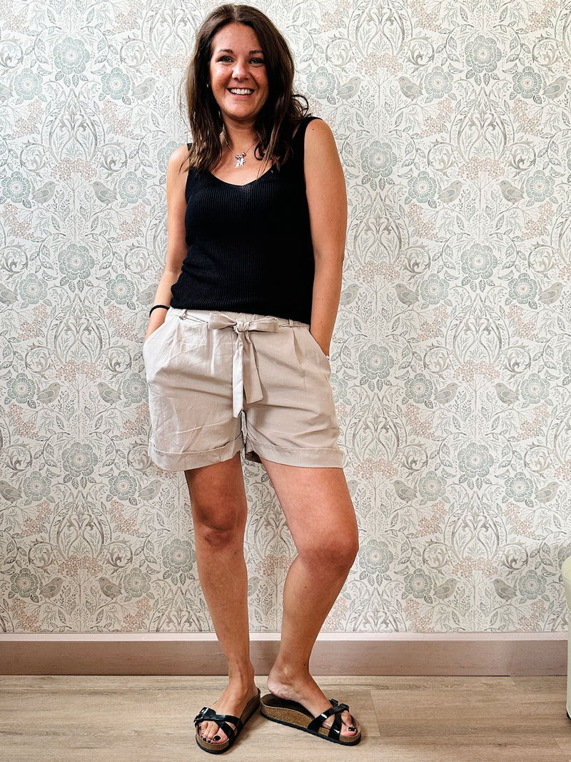 Top con scollo a V fronte e retro. Trama a costine e taglio dritto ed aderente.