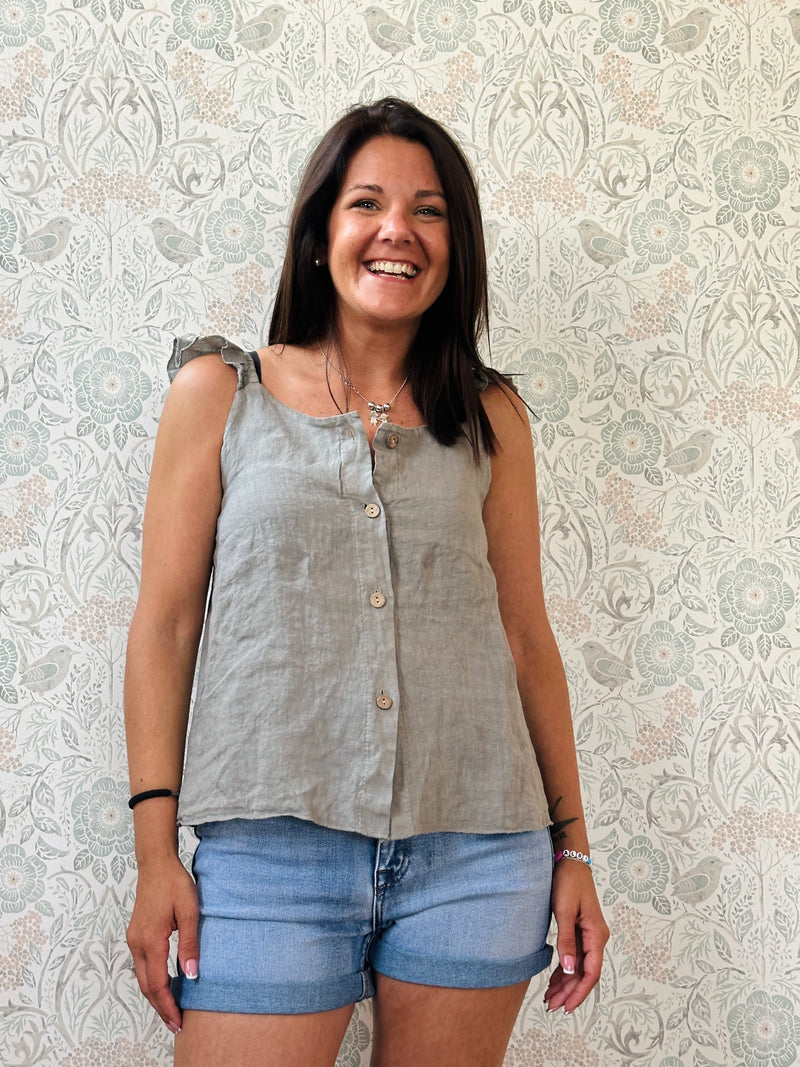 Top 100% lino, con spalline frou frou, leggermente svasato e chiusura con bottoni. 
