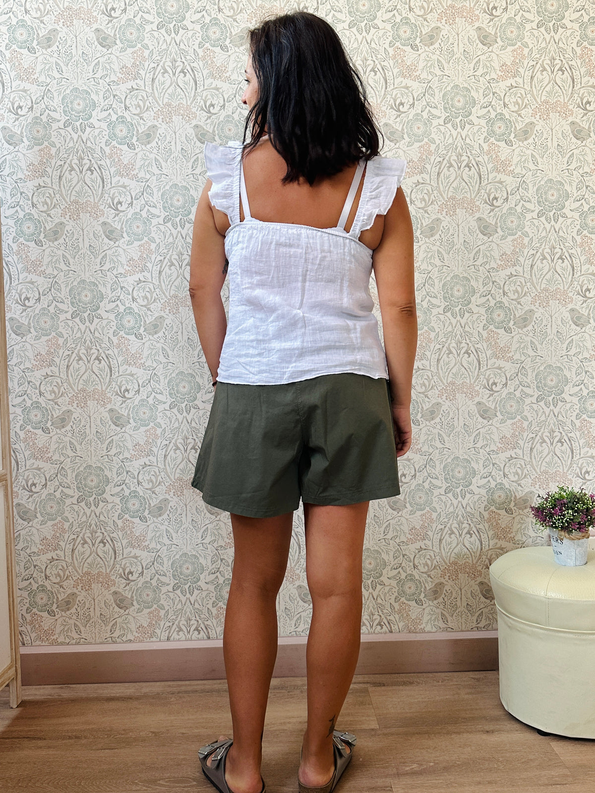 Top 100% lino, con spalline frou frou, leggermente svasato e chiusura con bottoni. 