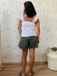 Top 100% lino, con spalline frou frou, leggermente svasato e chiusura con bottoni. 