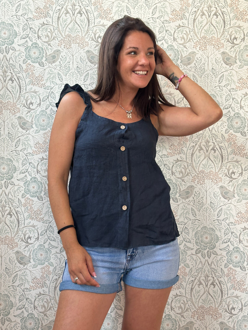 Top 100% lino, con spalline frou frou, leggermente svasato e chiusura con bottoni. 