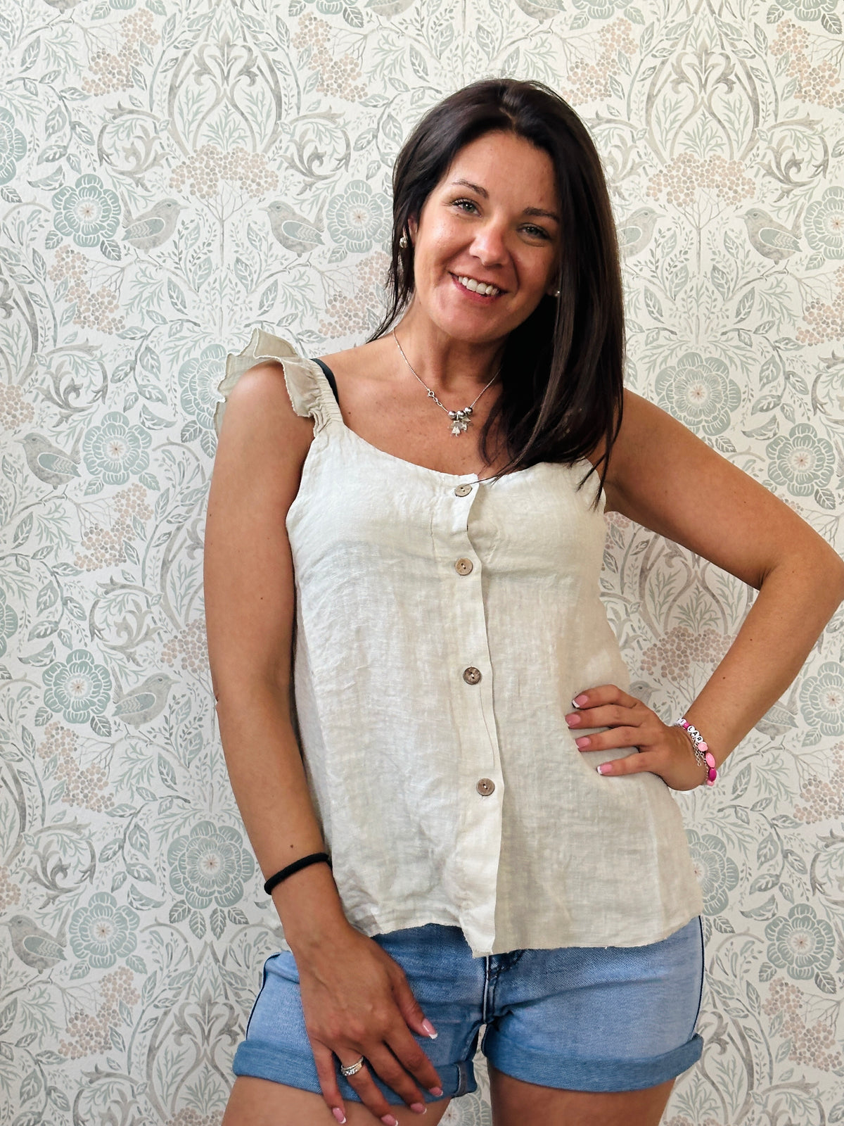 Top 100% lino, con spalline frou frou, leggermente svasato e chiusura con bottoni. 