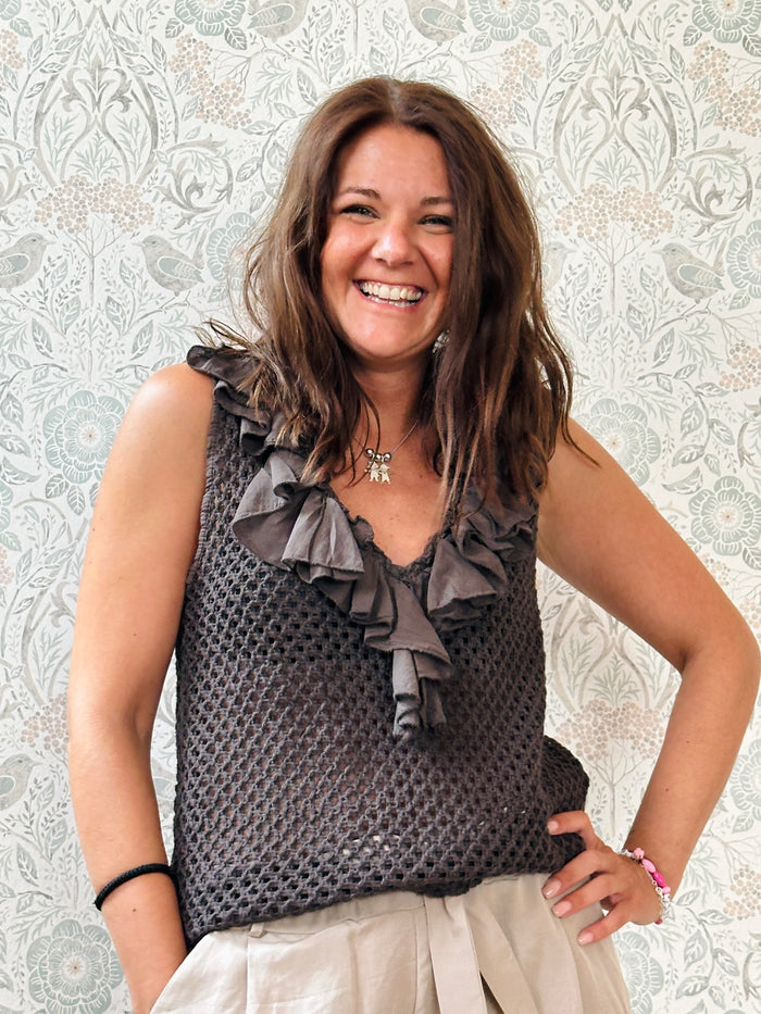 Top 100% cotone, marrone, traforato con scollo a v profondo. Dettaglio volant sullo scollo. 