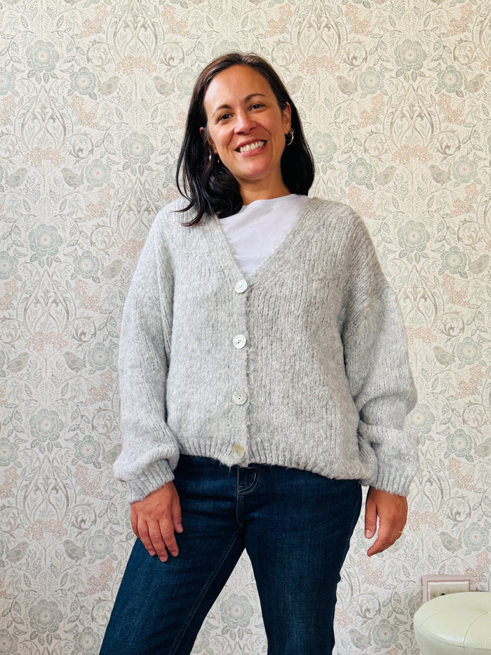 Cardigan da donna a trama grossa, scollo a V profondo e bottoni in madre perla. Vestibilità morbida e ampia. 