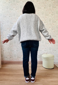 Cardigan da donna a trama grossa, scollo a V profondo e bottoni in madre perla. Vestibilità morbida e ampia. 