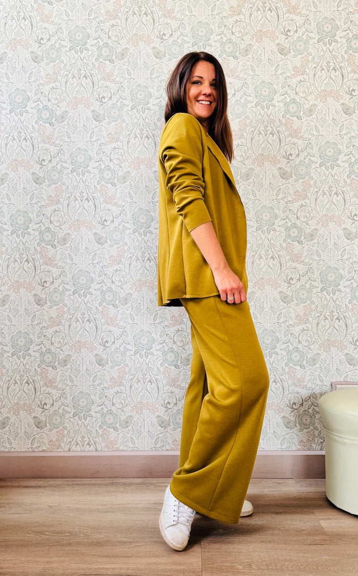 Completo composto da pantalone taglio palazzo con elastico in vita e coulisse e blazer aperto con colletto. Vestibilità morbida e molto versatile. 