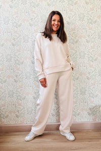 Completo composto da: Pantaloni con elastico in vita, taglio baggy e tasche sui fianchi. Felpa con scollo tondo ampia, svasata e con spacchetti laterali. 