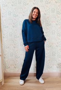 Completo composto da: Pantaloni con elastico in vita, taglio baggy e tasche sui fianchi. Felpa con scollo tondo ampia, svasata e con spacchetti laterali. 