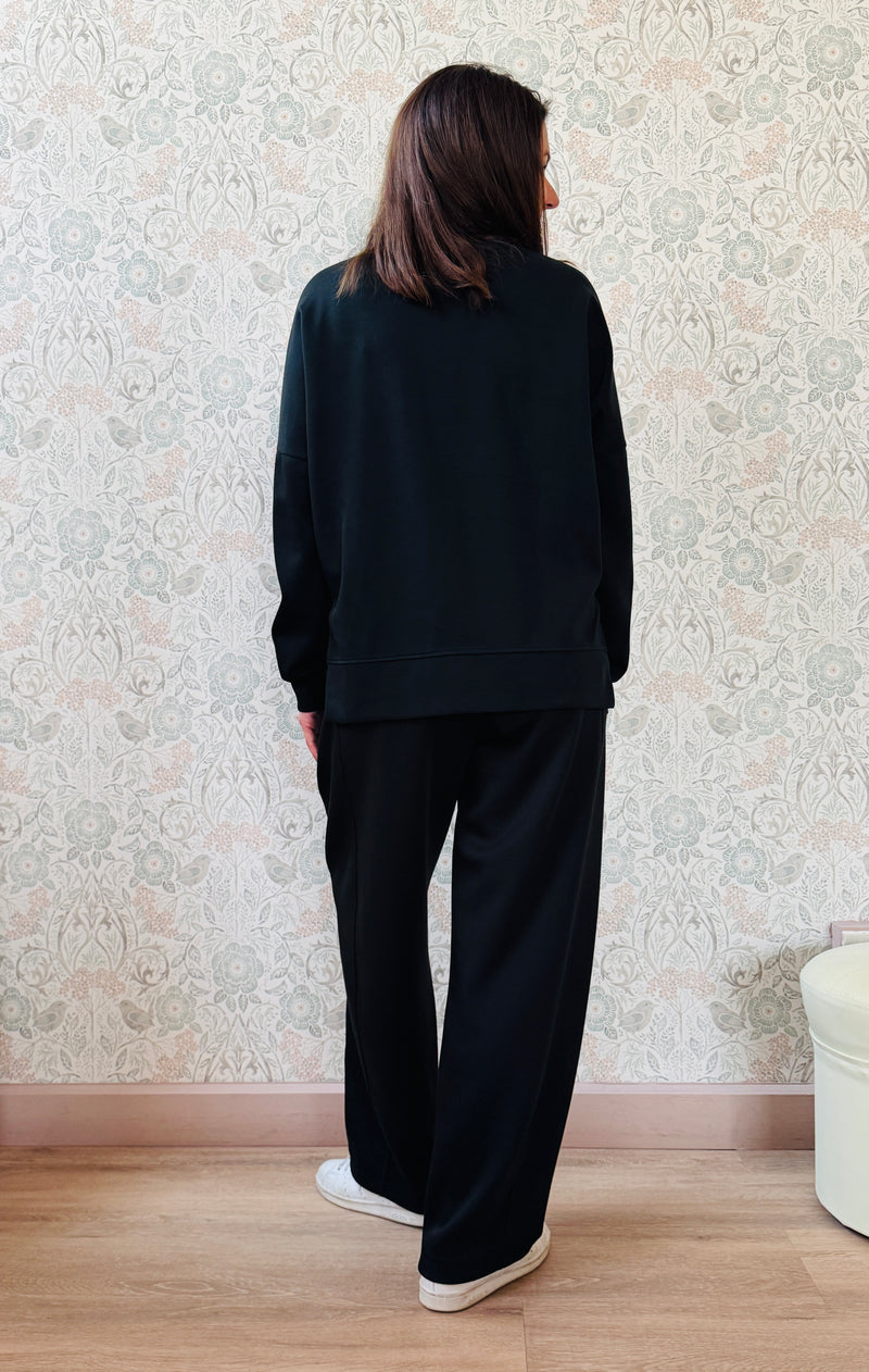 Completo composto da: Pantaloni con elastico in vita, taglio baggy e tasche sui fianchi. Felpa con scollo tondo ampia, svasata e con spacchetti laterali. 